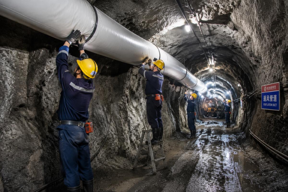 Installation team fitting lightweight PVC air ducts in an underground mine ventilation shaft