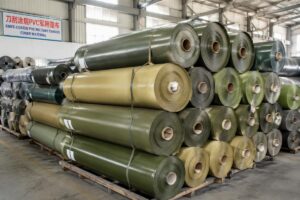 Stacked rolls of knife-coated PVC military canvas cover material in a factory warehouse